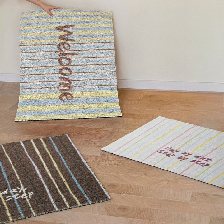 Woven door mat with welcome inscription, striped pattern and non-slip back