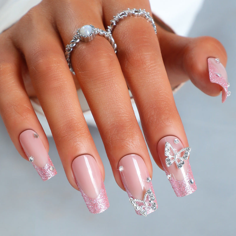 Acrylic nail set with sparkling glitter accents and elegant butterfly motifs Stornfield