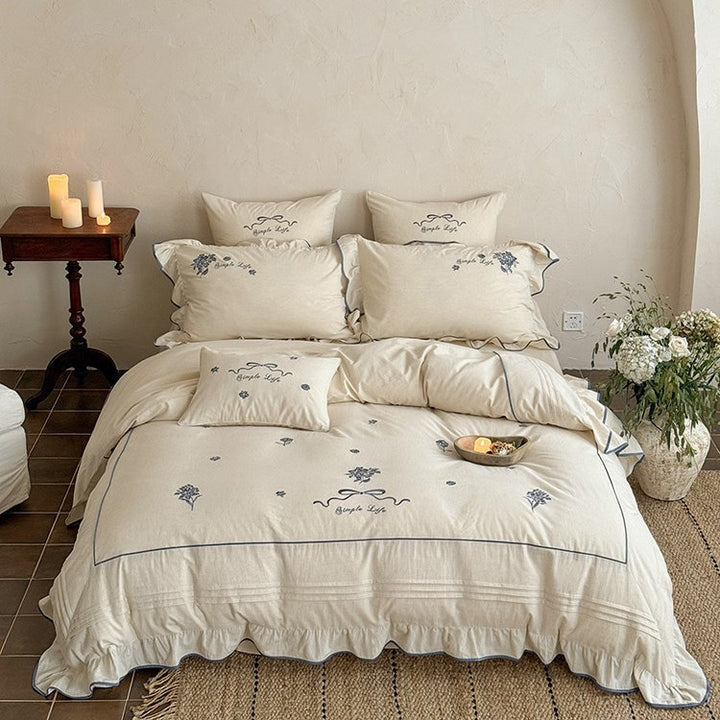Cotton muslin bedding set with delicate floral embroidery, ruffle, and breathable finish