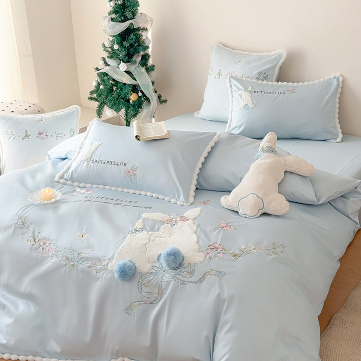 Playful cotton satin bedding set with appliquéd bunny pom-pom trim and floral embroidery