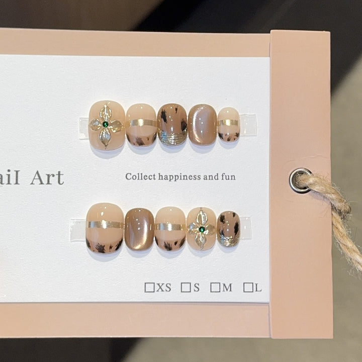 Artificial nails with elegant gold embellishments Stornfield