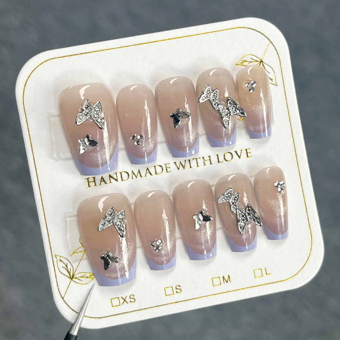Artificial nail extensions with glitter design and elegant accents Stornfield