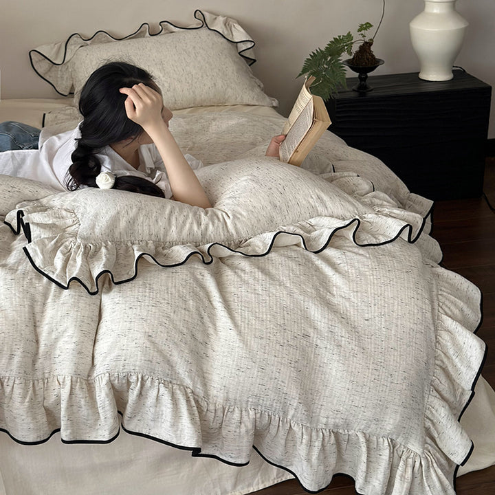 Playful ruffle bedding set in linen look with contrasting piping and soft wash