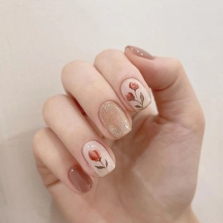 Artificial nail art with colorful flower design and glitter accents Stornfield