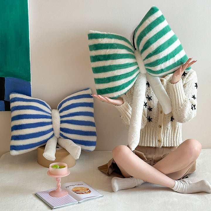 Cuddle cushion in bow shape made of plush with striped texture