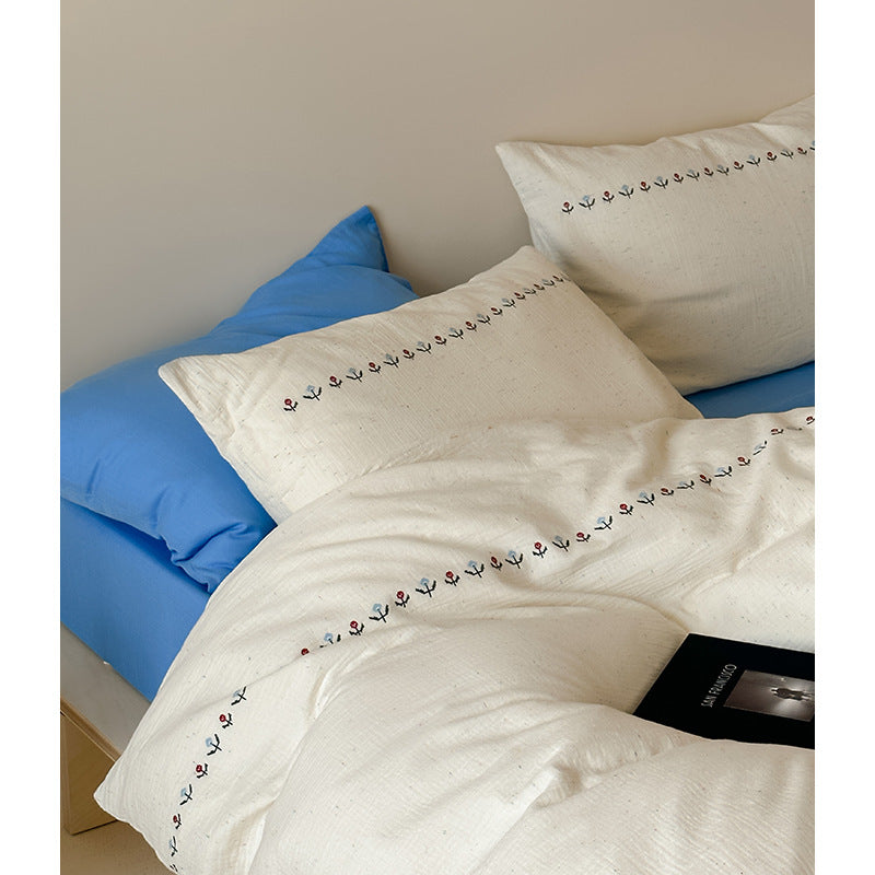 Cotton gauze bedding set with delicate border embroidery and mottled nep structure