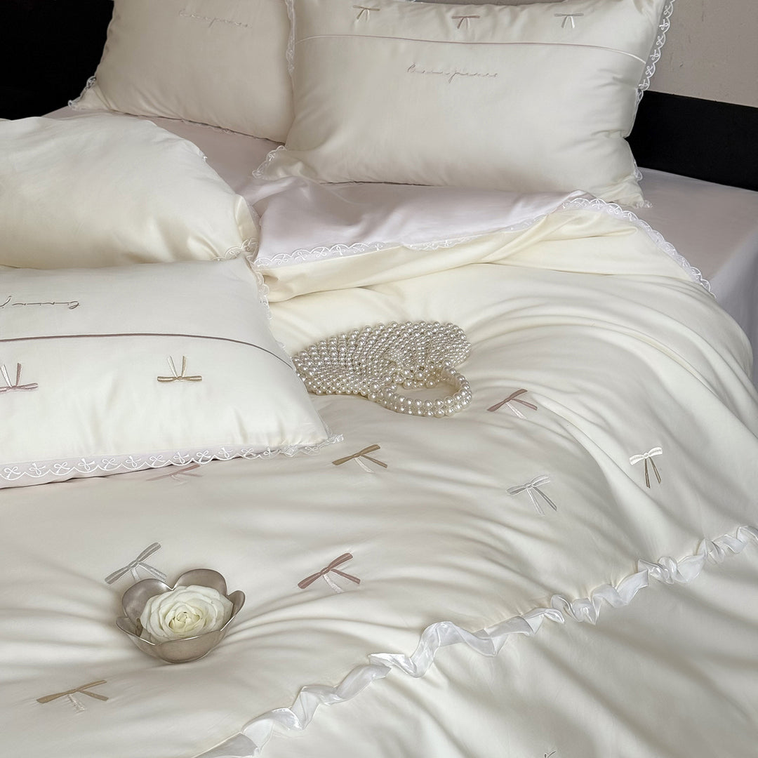 Bedding set made of cotton satin with embroidered bows and lace ruffle
