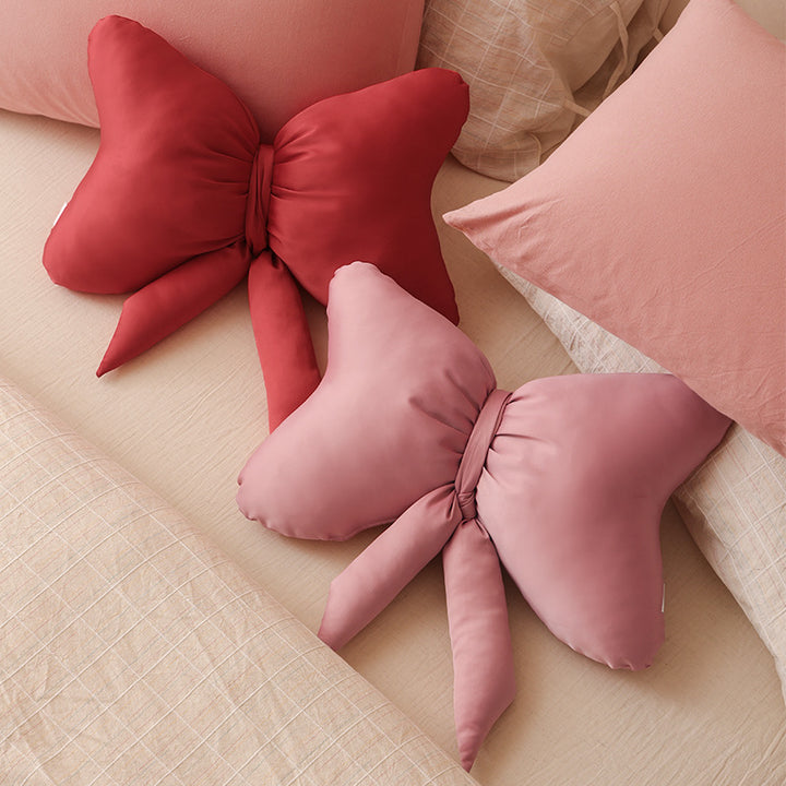 Bow-shaped decorative pillow with soft microfiber cover and decorative ribbons