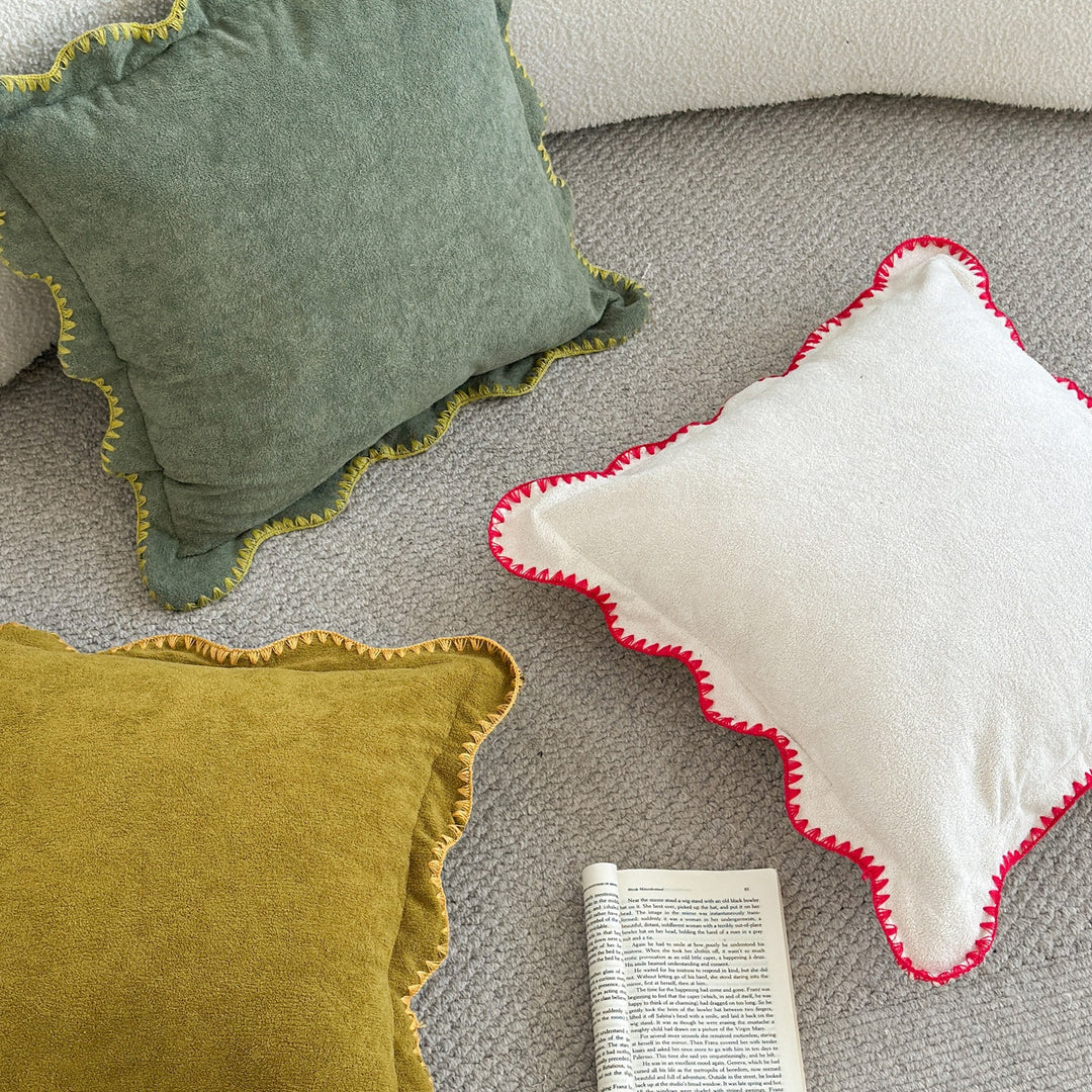 Decorative velvet cushion with wavy edge and decorative stitching