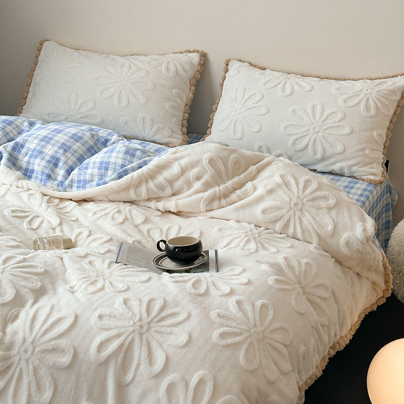 Plush bedding set with embossed floral relief and teddy trim