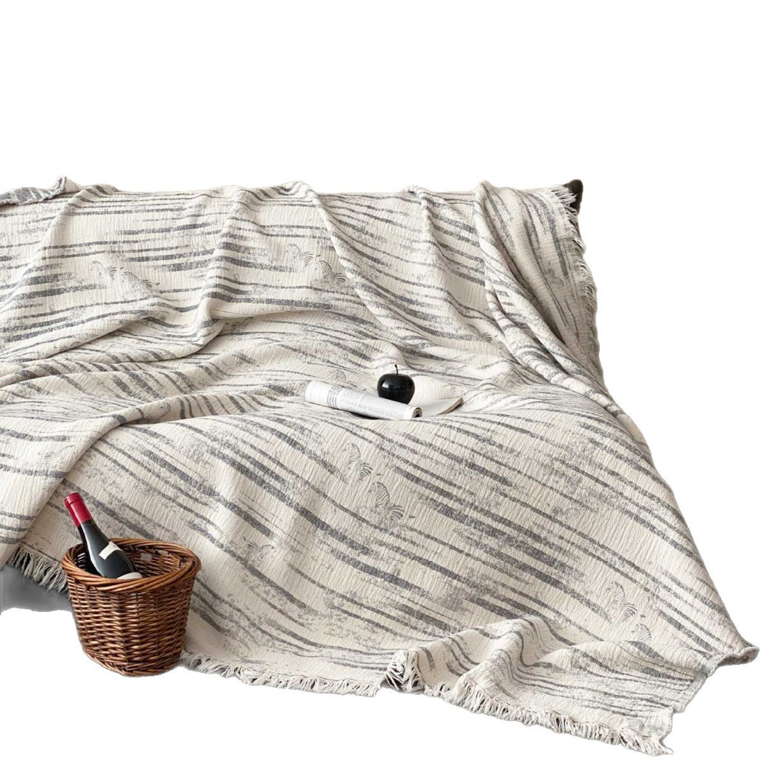 Cozy living blanket made of cotton blend fabric with fringes and striped texture
