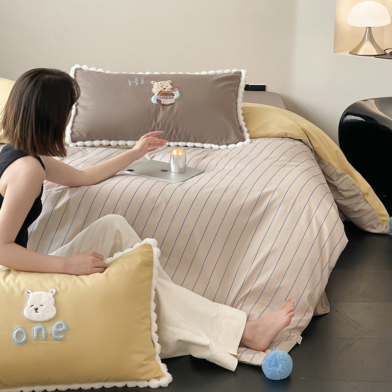 Children's bed set with teddy bear embroidery, pom-pom edging, and reversible blanket