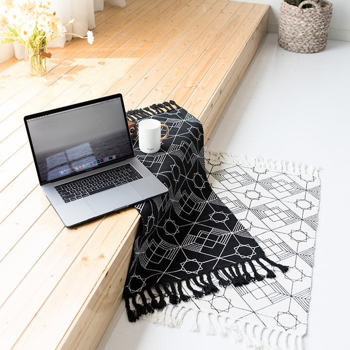 Flat-woven cotton table runner in Art Deco geometry jacquard with hand-fringed edge