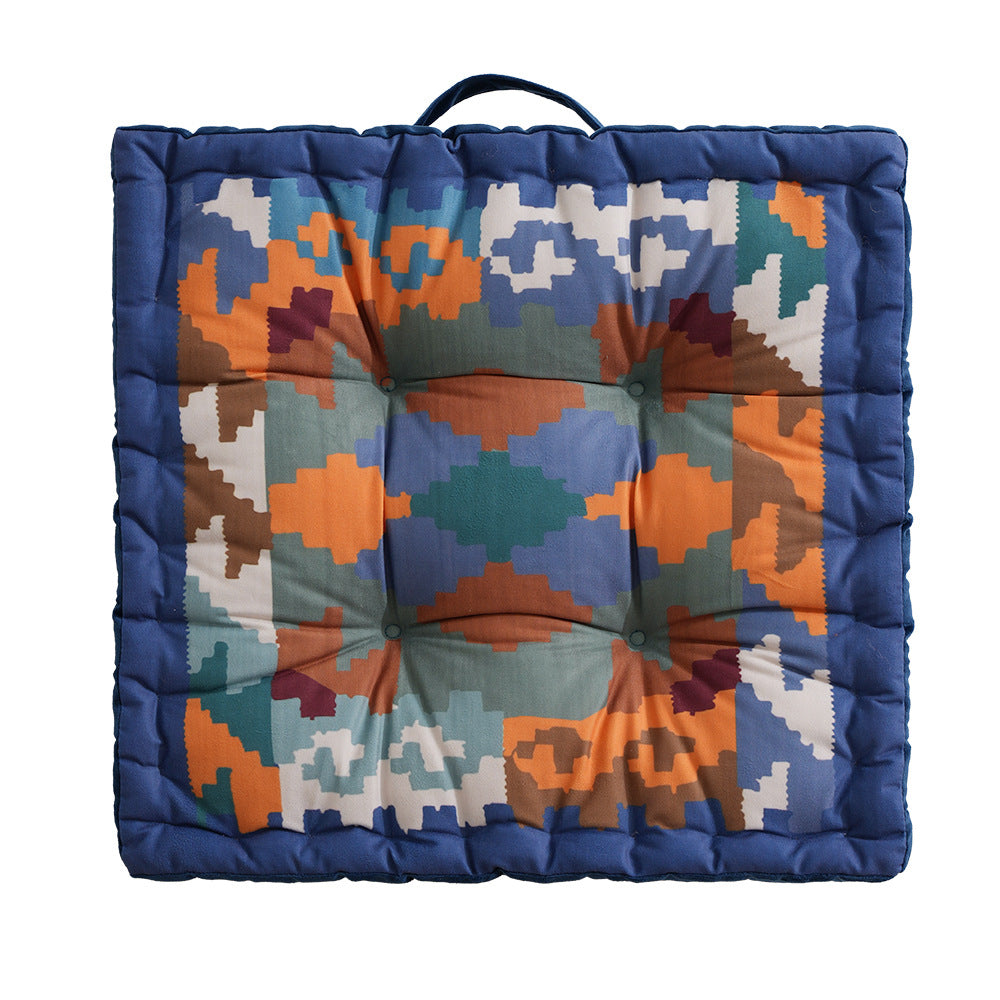 Square seat cushion with kilim-inspired pattern, quilted padding and carrying handle