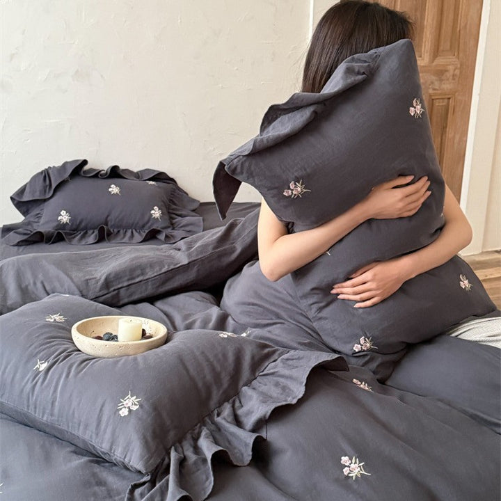 Cotton satin bedding set with delicate embroidered flowers, ruffled decorative pillow, and hotel closure Stornfield