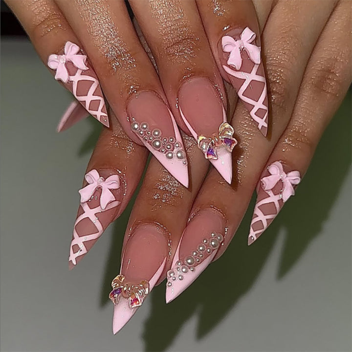Artful stiletto nails with glitter and bow decoration Stornfield