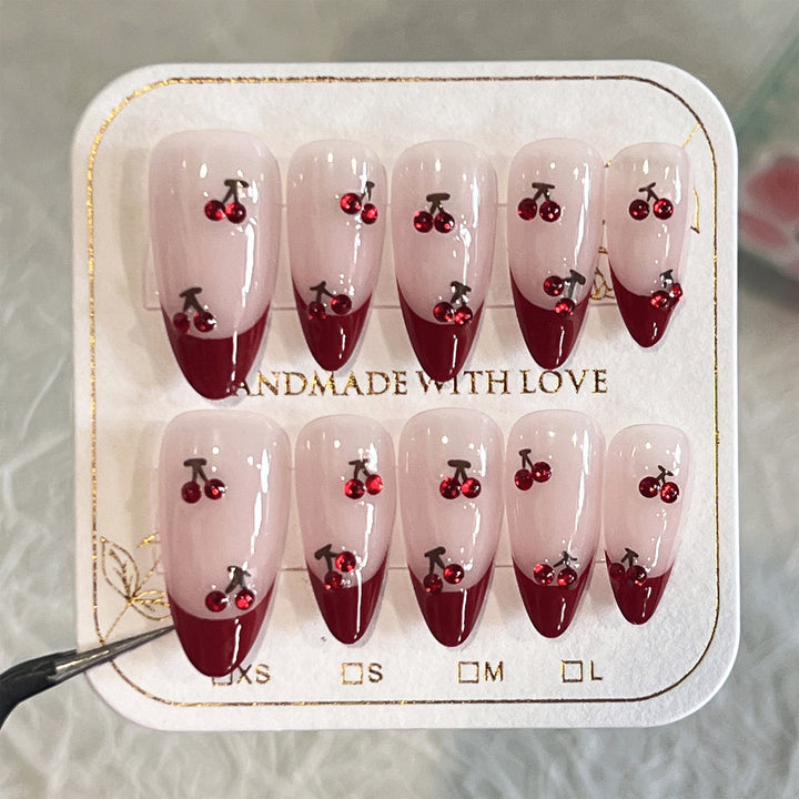 Artful stiletto nails with cherry motifs and glitter accents Stornfield