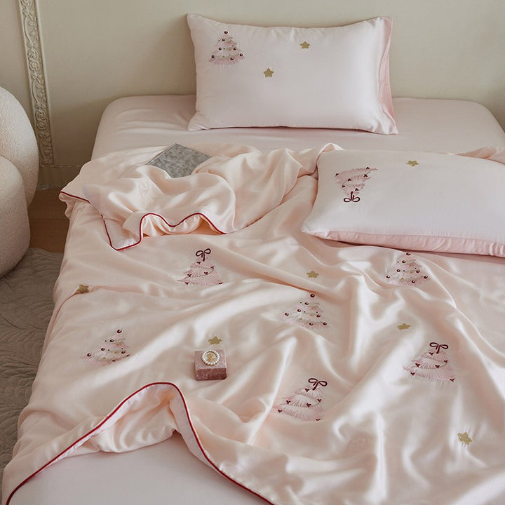 Luxurious satin bed linen set with embroidered Christmas tree motifs and contrasting piping