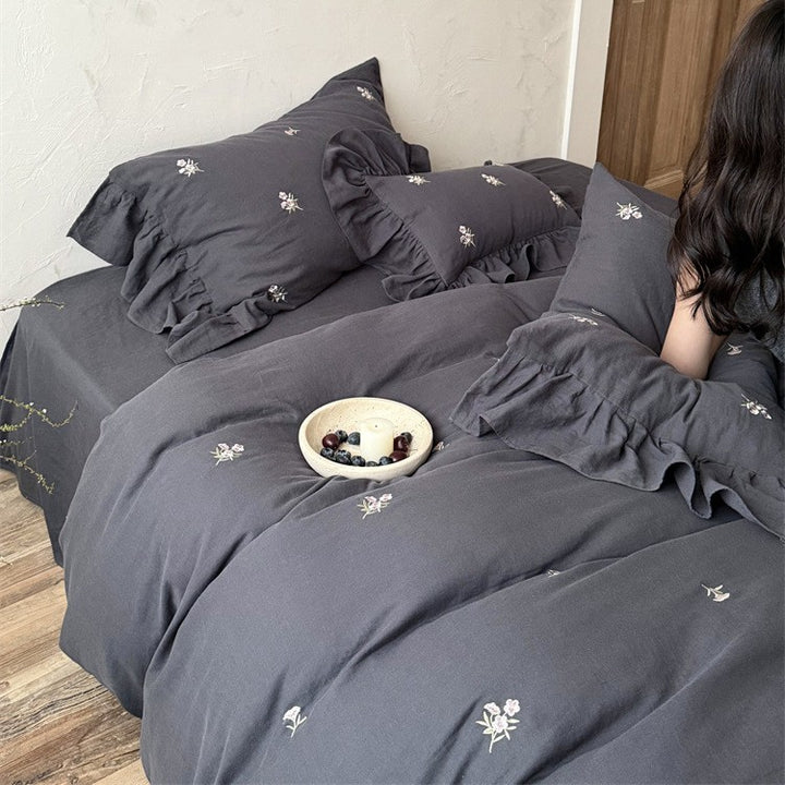 Cotton satin bedding set with delicate embroidered flowers, ruffled decorative pillow, and hotel closure Stornfield