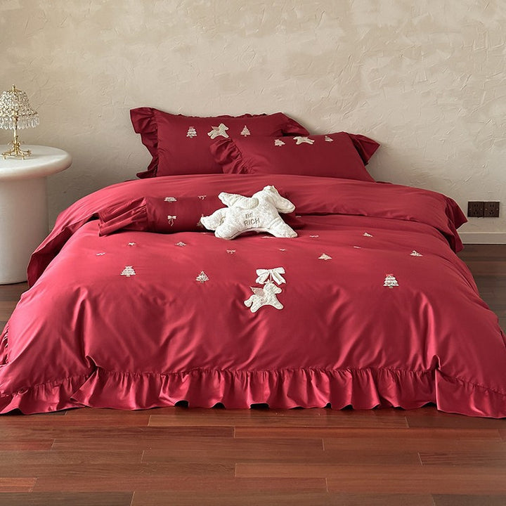 Festive satin bedding set with embroidered pine and mythical creature appliqués and ruffled cushion