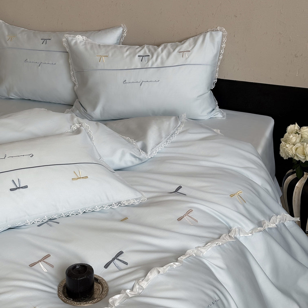 Bedding set made of cotton satin with embroidered bows and lace ruffle
