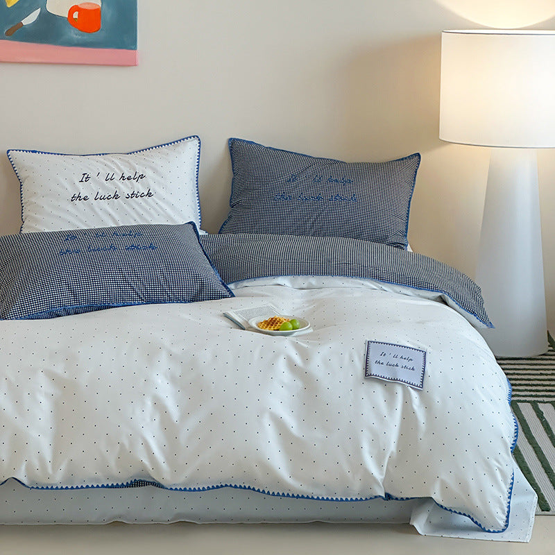 Striped cotton bedding set with subtle slogan appliqués and decorative piping