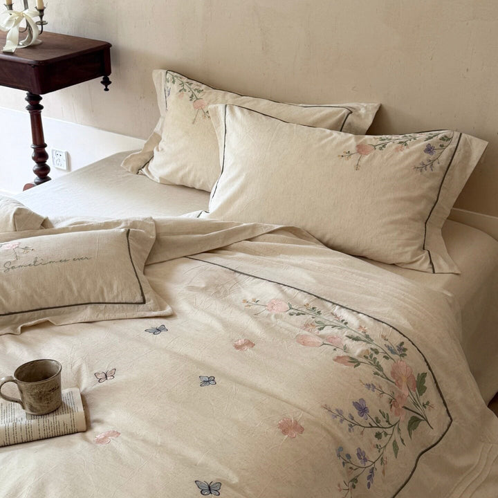 Natural fiber duvet cover set with delicate floral hand embroidery, linen look, and decorative ruffle