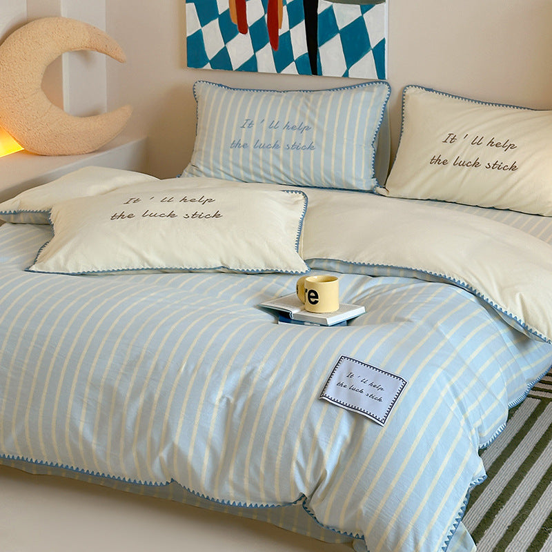 Striped cotton bedding set with subtle slogan appliqués and decorative piping