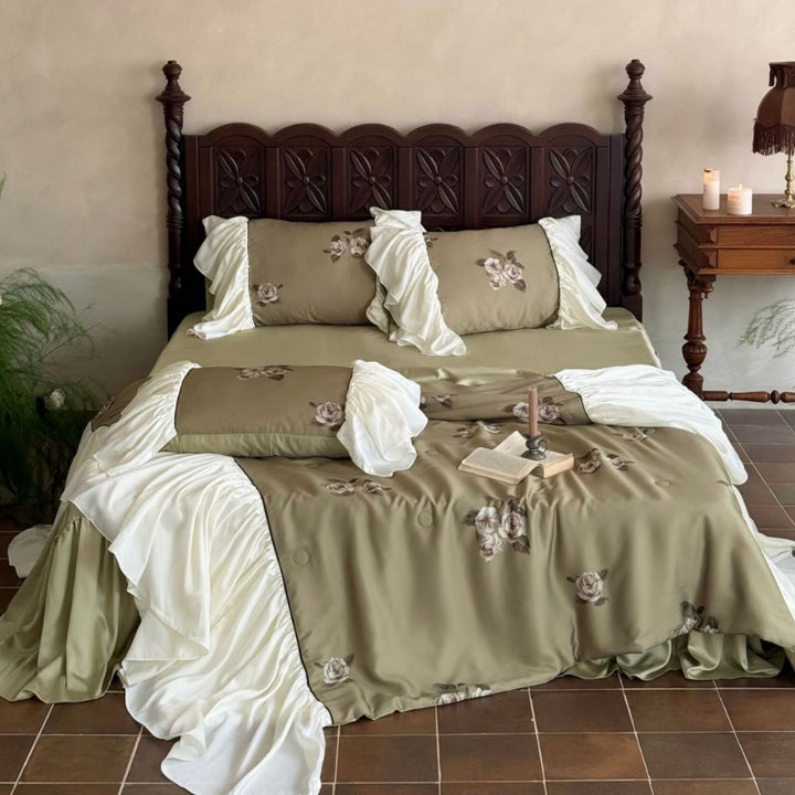Vintage-inspired satin bedding with elaborate ruffled flounces and rose embroidery