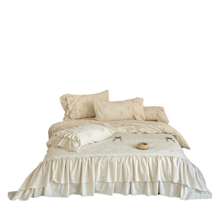 Romantic cotton bedding set in country house style with embroidered bedspread, ruffled bed skirt, and frill pillow.