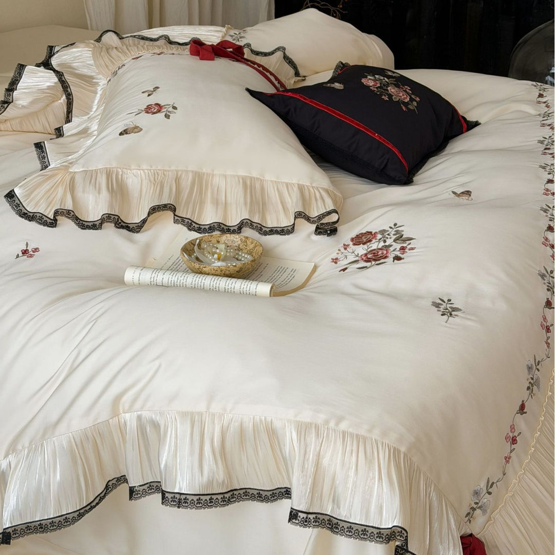 Elegant satin bedding set with pleated ruffle, rose embroidery, and bow appliqué