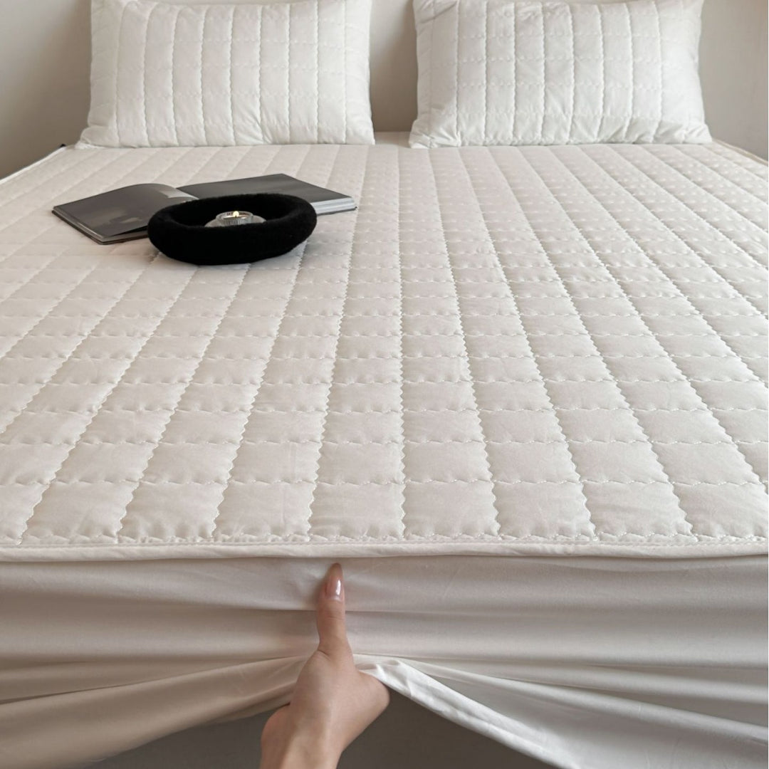 Padded quilted mattress topper with non-slip bottom and breathable fiber filling