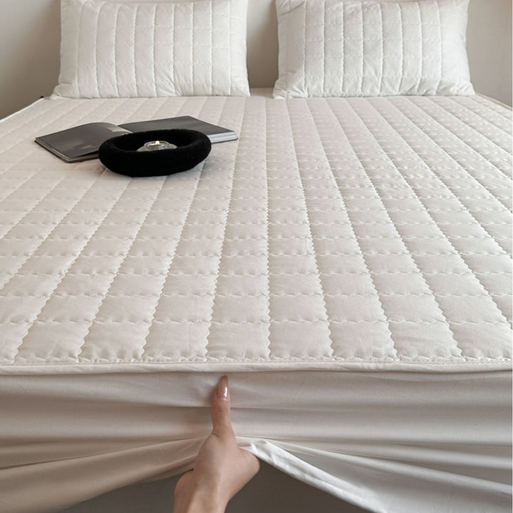 Padded quilted mattress topper with non-slip bottom and breathable fiber filling