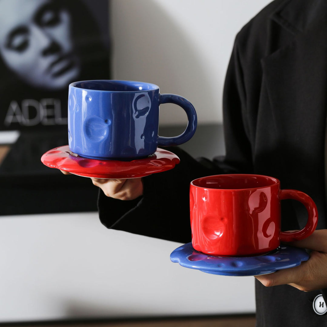 Ceramic coffee cup set with textured relief surface and wavy saucer
