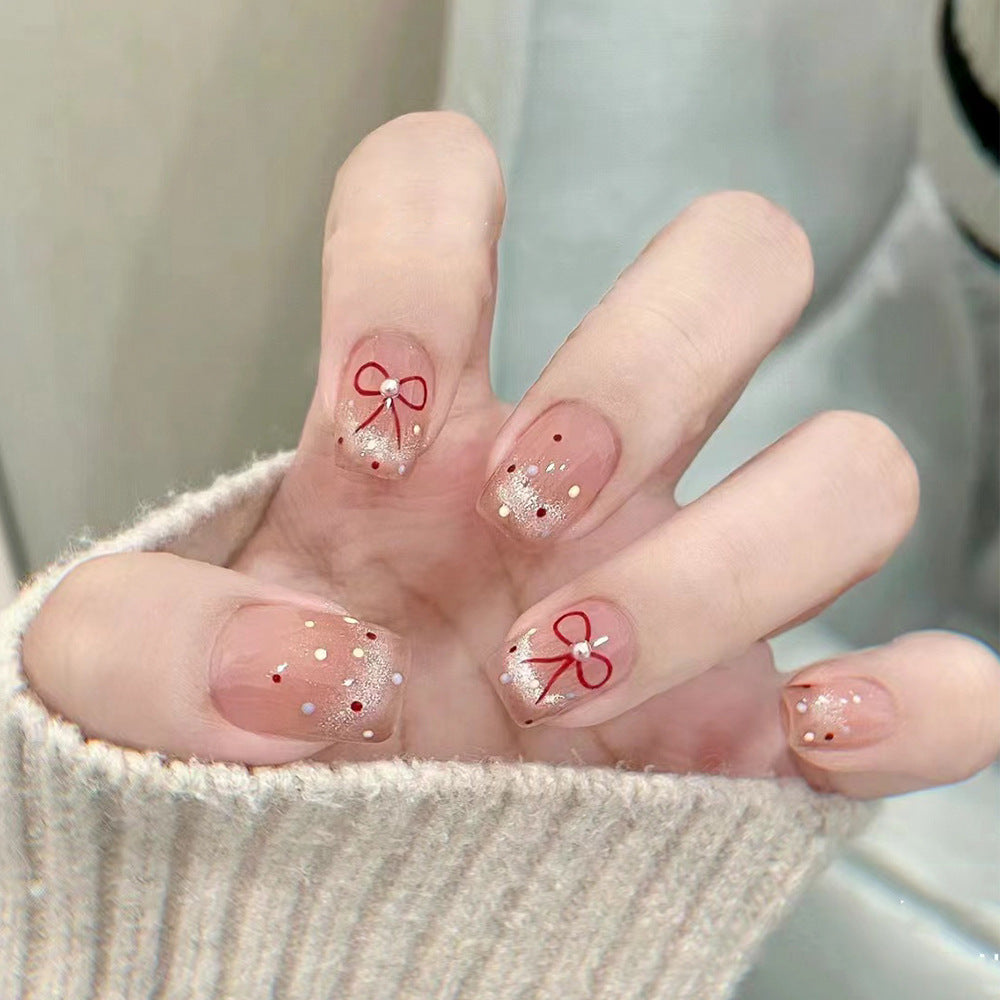Artificial nail art with elegant bows and glitter accents Stornfield