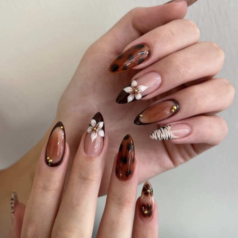 Artistic stiletto nails with elegant floral designs and glitter accents Stornfield