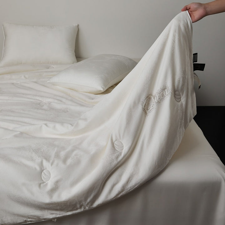 Quilted comfort duvet with fine jacquard structure and decorative button quilting
