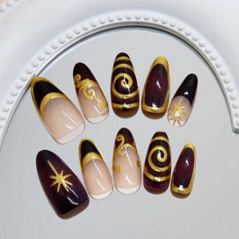 Acrylic nail set with elegant spiral patterns and glamorous golden accents Stornfield