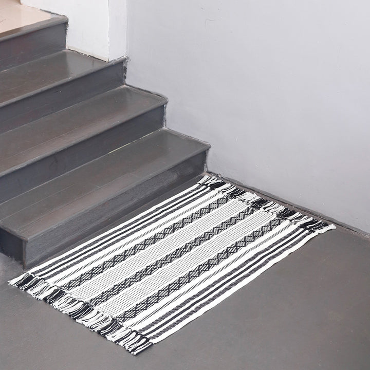 Handwoven cotton runner with low pile, fringes, and geometric stripe pattern