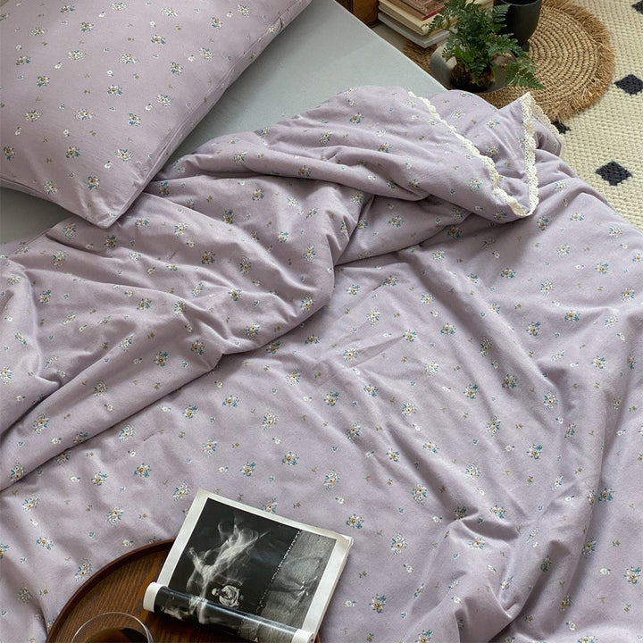Quilted throw blanket made of cotton blend with delicate floral pattern and lace edge