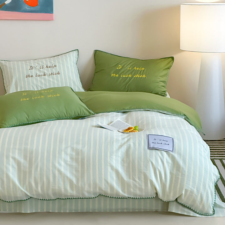 Striped cotton bedding set with subtle slogan appliqués and decorative piping