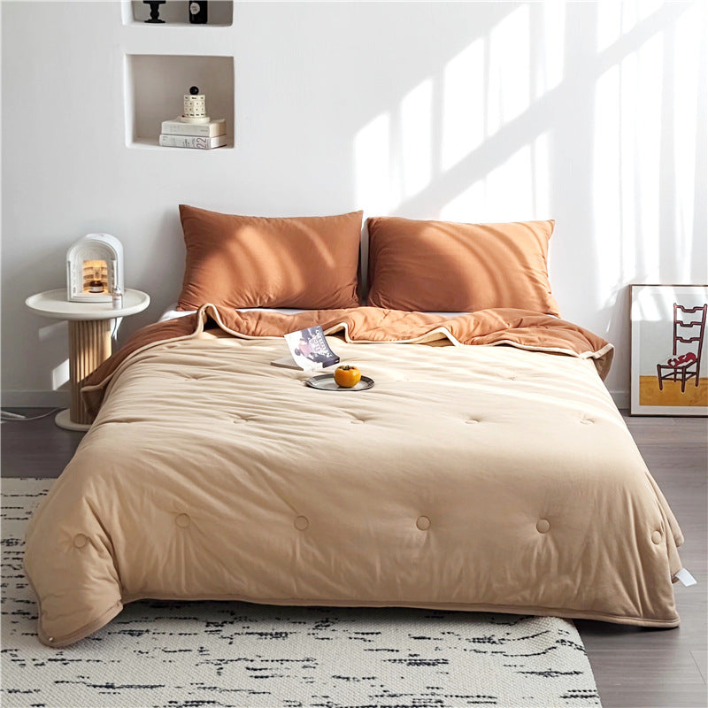 Light reversible quilted blanket made of microfiber with soft decorative stitching
