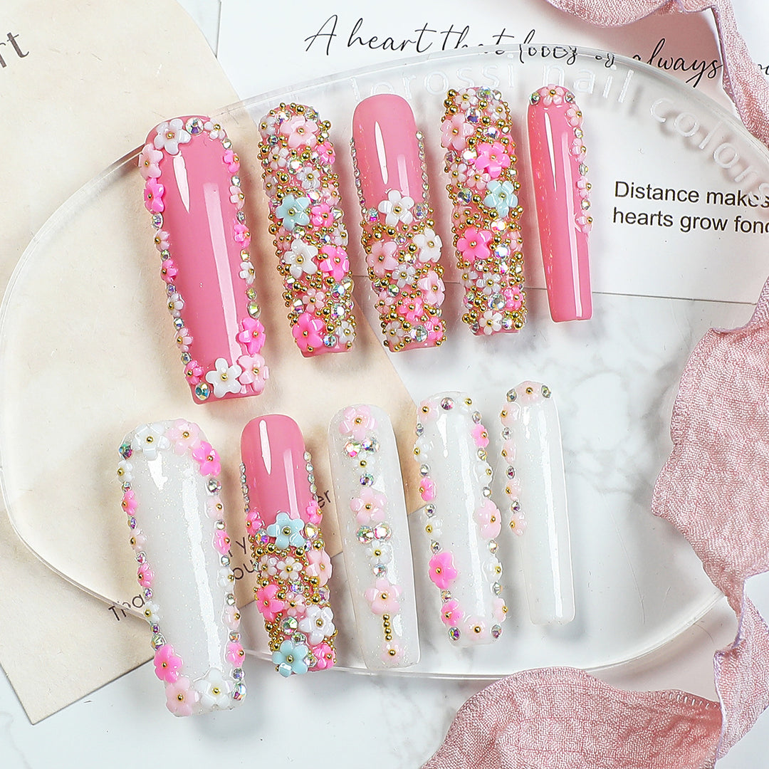 Artificial nail set with floral decorations and glitter accents Stornfield