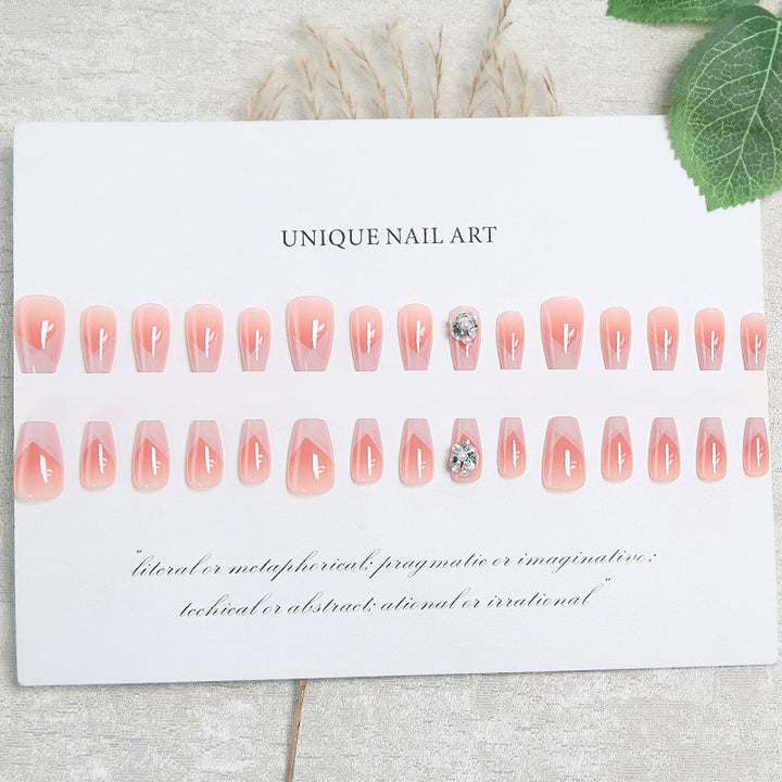 Artificial nail set with filigree tip designs and glamorous rhinestone accents Stornfield
