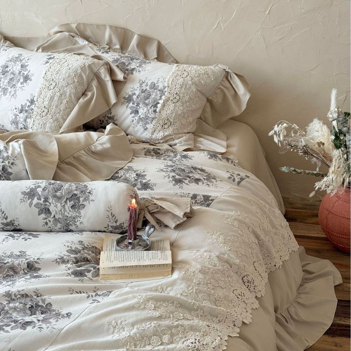 Bedding set in French country house style with lace trim, ruffled bed skirt, and subtle toile floral design
