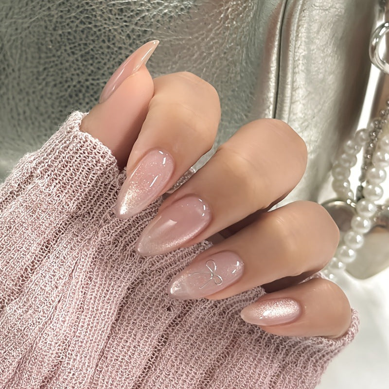 Artificial nail set with delicate glitter and elegant bow decorations Stornfield