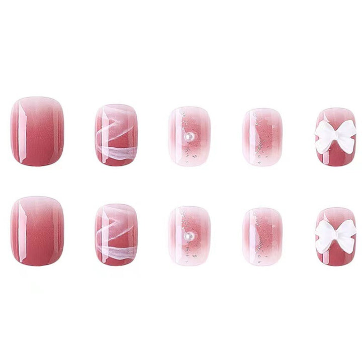 Glamorous nail art with pearl and bow accents Stornfield