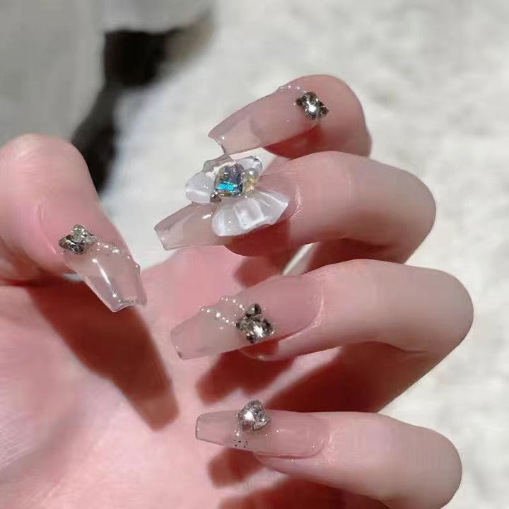 Artistic Nail Art with Glitter and Flower Applications Stornfield