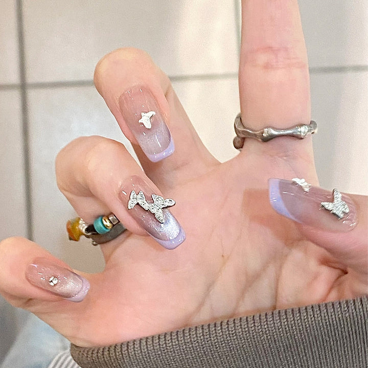 Artificial nail extensions with glitter design and elegant accents Stornfield
