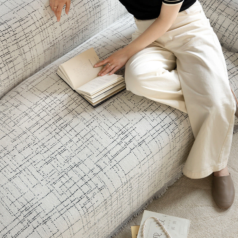 Universal sofa throw made of woven cotton blend with fringes and gentle upholstery cover Stornfield